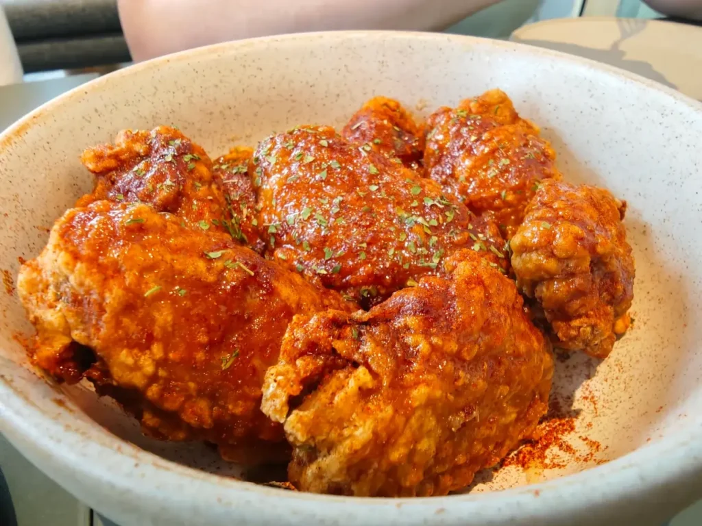 Honey paprika crispy wings and charred Brussels sprouts, showcasing the best Tampines Mall food at Lola's Cafe.